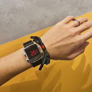 Close-up wrist detail of a trendy digital LED electronic watch with sleek square case and buttons.