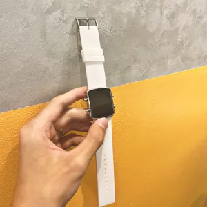 Detail shot of a white silicone strap digital watch with a silver square case for daily wear.