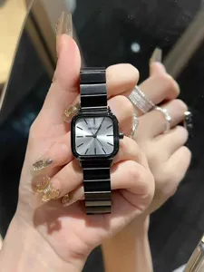 Women black square watch with silver dial and sleek metal strap, elegant vintage timepiece detail.
