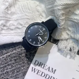 Close-up detail of the black quartz watch with white numbers, date display, and clean dial design.