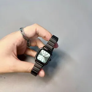 Close-up detail view of the elegant black square quartz watch with sleek metallic strap.