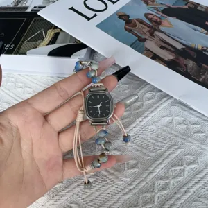 Nahaufnahme Detail der Quarzarmbanduhr mit Perlen geflochtenem Armband und kleinem Zifferblatt.