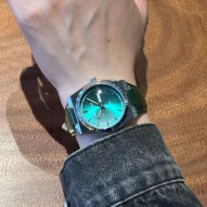 Vista dettagliata al polso di orologio al quarzo da uomo con quadrante verde e cinturino.