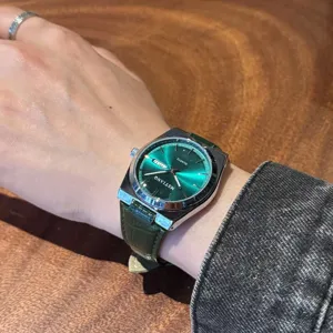 Primo piano dettaglio di un orologio al quarzo da uomo verde con cinturino in pelle.