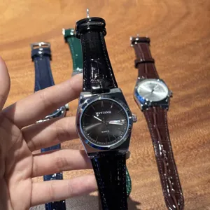 Dettaglio dell'orologio da uomo al quarzo con quadrante chiaro e cinturino in pelle.