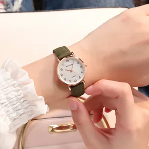 Gros plan detail de montre pour femme bracelet vert et cadran blanc vue sur le poignet.
