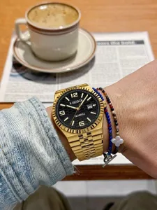 Gold quartz men wristwatch with black patterned dial calendar display and metal bracelet lifestyle