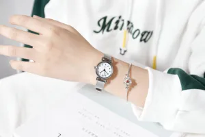 Minimalist women's quartz watch with mesh strap and elegant flower bracelet set for daily wear.