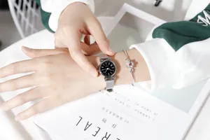 Minimalist women quartz watch with black dial and silver mesh strap for daily wear.