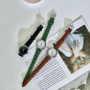 Retro vintage style small dial quartz wristwatch with slim strap detailed view flat lay.