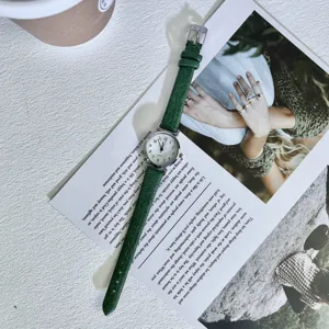 Chic vintage women quartz watch with slender green leather strap and small round dial.