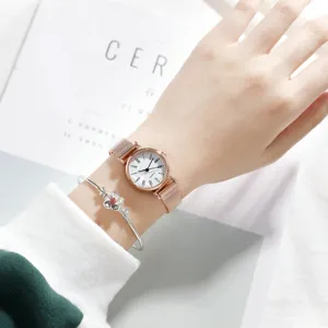 Close-up detail of women minimalist rose gold quartz watch with mesh strap and flower bracelet.