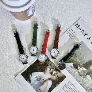 Vintage minimalist quartz watch with small dial and slim leather strap for women.