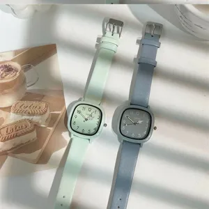 Detailed shot of minimalist square quartz watches in mint green and grey-blue with leather straps.