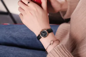 Detail shot of a women's quartz watch with black leather strap and rose gold small dial.