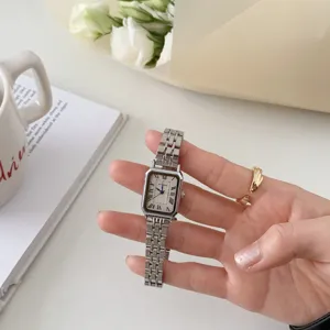 Primo piano di un orologio al quarzo da donna rettangolare con cinturino in metallo e numeri romani.