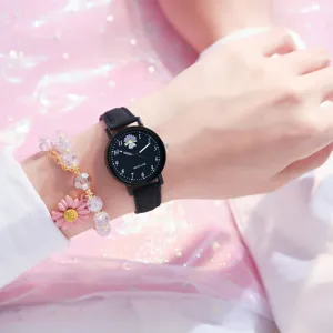Nahaufnahme einer schwarzen Gänseblümchen-Uhr mit passendem rosa Perlenarmband.