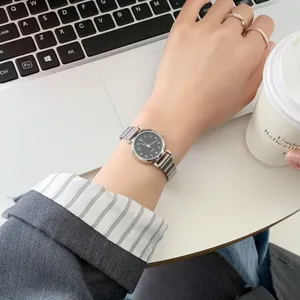 Closeup detail view of vintage women quartz watch with metallic mesh strap worn on wrist.