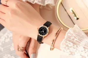 Close-up detail view of women's quartz wristwatch featuring a chic black leather strap and small dial.