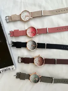 Detailed flat lay shot showing five colorful canvas strap wristwatches with clear dials.