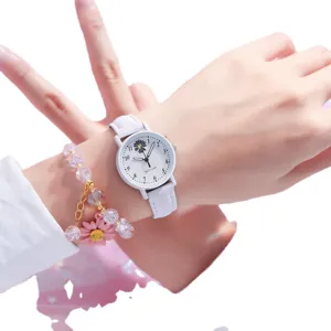 Weiße Gänseblümchen Quarzuhr mit rosa Anhänger Armband, am Handgelenk getragen Hauptansicht.