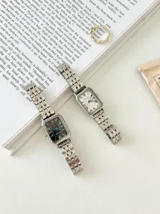 Elegante orologio da polso rettangolare con cinturino in metallo e numeri romani, stile vintage.