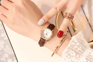 Detailed view of the women's small dial quartz watch with brown leather strap on wrist.