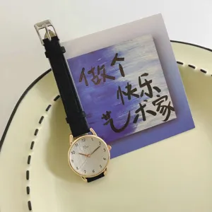 Detailed close-up of minimalist women wristwatch, white brushed dial with clear numerals.