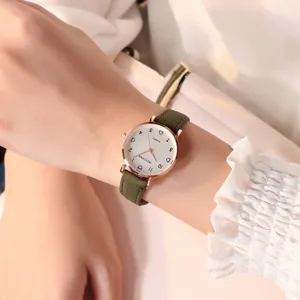 Gros plan détaillé d'une montre quartz minimaliste pour femme avec bracelet vert et cadran.