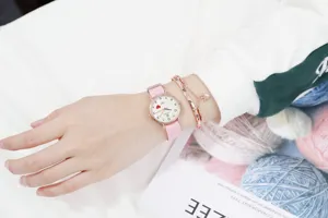 Minimalist pink nylon strap women's watch with cute heart dial design and matching bracelets.