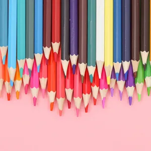 Close-up detail of colorful drawing pencils neatly arranged on pink background for art painting.