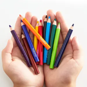 Detailed shot of colorful mini wooden drawing pencils held in hands, vibrant shades.