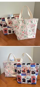 Vue détaillée du sac à lunch bento en toile imperméable avec de jolis imprimés chat et fleurs.