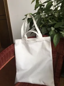 Detailed close-up view of plain white canvas tote bag, perfect for custom DIY craft use.
