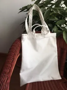 Detail view of a plain white canvas tote bag with double handles, perfect for DIY and daily use.