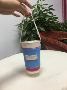 Wiederverwendbare blaue Leinen Tassenhülle mit weißem Tragegurt für Kaffee und Teetassen.