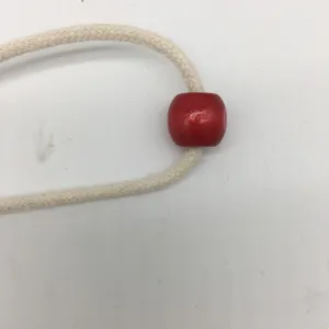 DIY canvas pouch drawstring detail showing beige braided rope and red wooden bead accessory close up