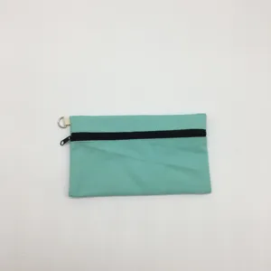 Detailansicht der minzgrünen Canvas-Reißverschlusstasche mit schwarzem Zipper und Metall-D-Ring.