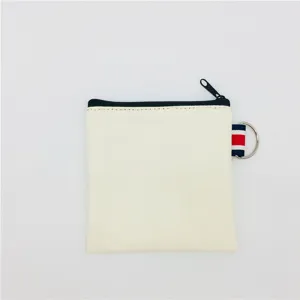 Canvas coin purse detail showing black zipper closure and side D-ring ribbon loop.