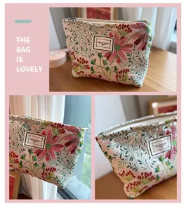 Primo piano sui dettagli della trousse in tela ricamata con motivi floreali e pratica cerniera.