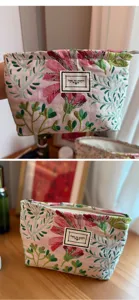 Nahaufnahme Detail der rosa blumigen Kosmetiktasche mit gewebtem Blumenmuster und Reißverschluss.