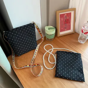 Sac bandoulière noir à pois avec sangle colorée et chaîne de perles pour le quotidien.