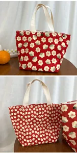 Detailed view of the red floral canvas lunch bag, featuring cute daisy print and handles.