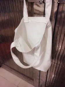 Plain white canvas tote bag detail, durable DIY blank shopping bag with double straps.