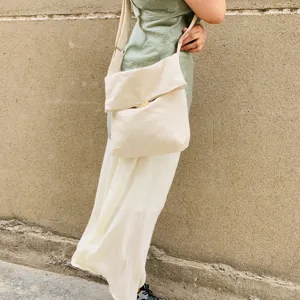 Detailaufnahme einer lässigen beige Segeltuch Umhängetasche am Modell, ideal für den Alltag.