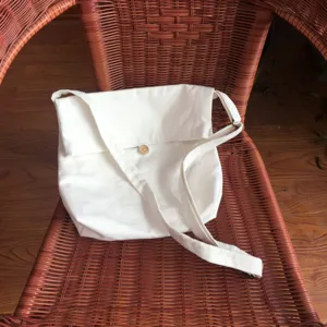 Einfache weiße Canvas Umhängetasche mit Klappverschluss und Holzknopf für den Alltag.