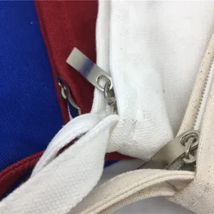 Nahaufnahme der Stofftasche mit Reißverschluss, Texturdetails und bunten gestapelten Beuteln.