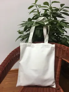 Detailansicht der schlichten weißen Segeltuch-Tragetasche auf Rattanstuhl präsentiert.