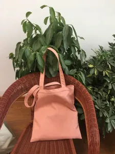 Vista detallada del bolso tote de lona rosa liso, ideal para el trayecto diario y los estudiantes.