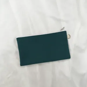 Dunkelgrüne Canvas-Reißverschlusstasche Detail, schlichte Münztasche mit weißem Reißverschluss.